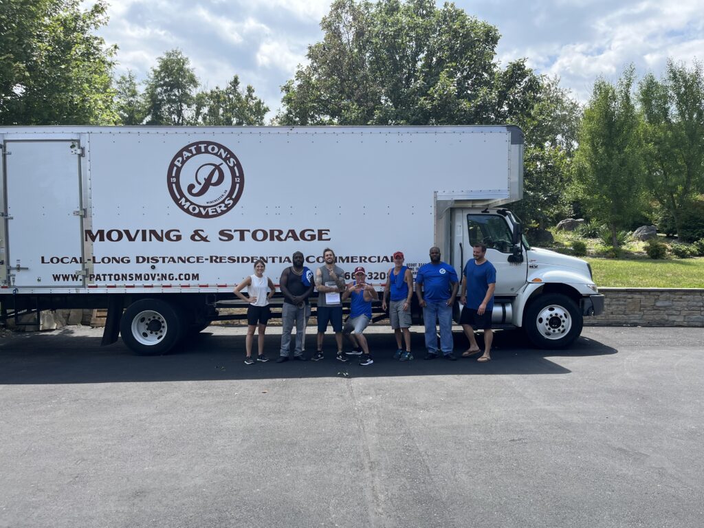 The Pattons Movers team posing in front of their branded moving truck, ready to assist with local and long-distance moving services in Winchester, VA.