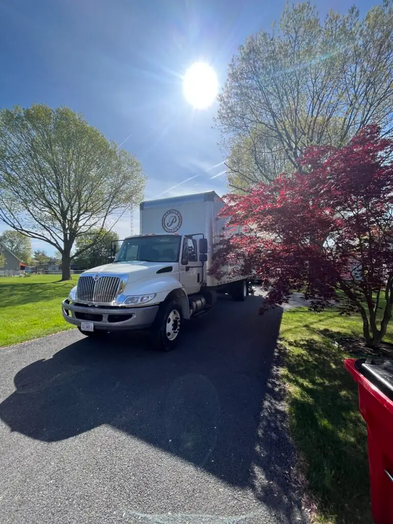 Pattons Movers truck parked in a beautiful residential neighborhood under the bright sun, providing professional moving services in Winchester, VA.